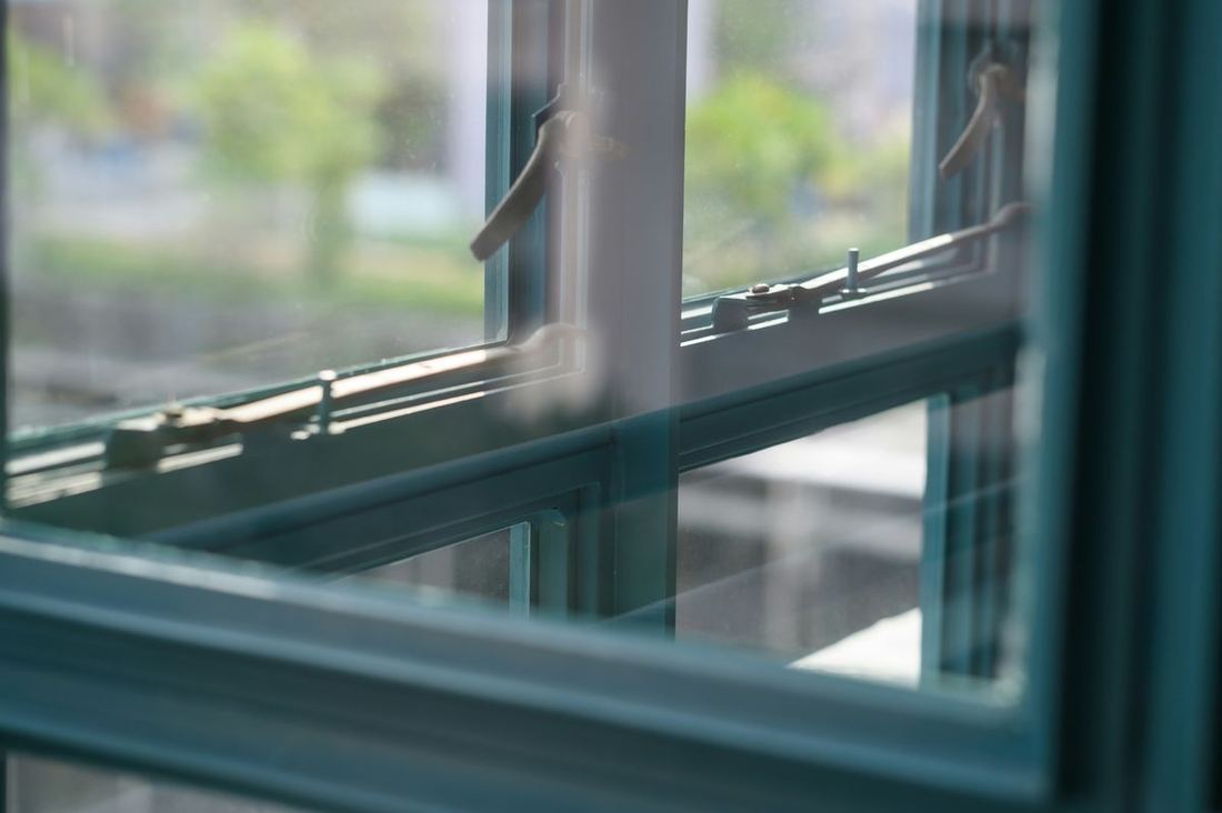 Detailopname van het hang- en sluitwerk en de beglazing van een kozijn