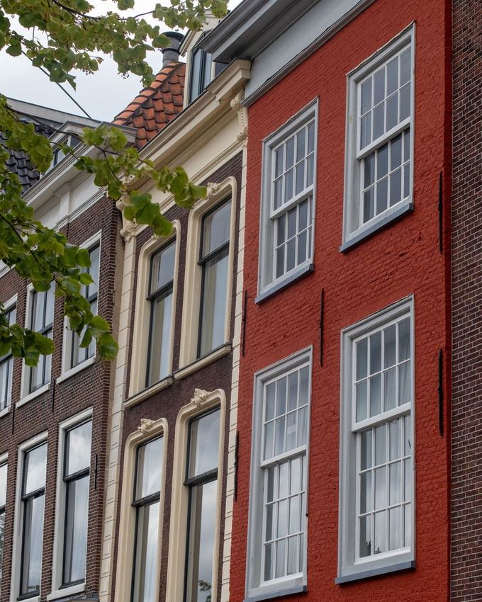 Rij karakteristieke stadswoningen met houten schuifvensters