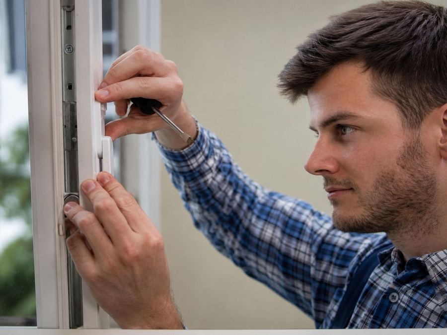 Monteur van HAK Kozijnen stelt het hang- en sluitwerk van een kozijn af